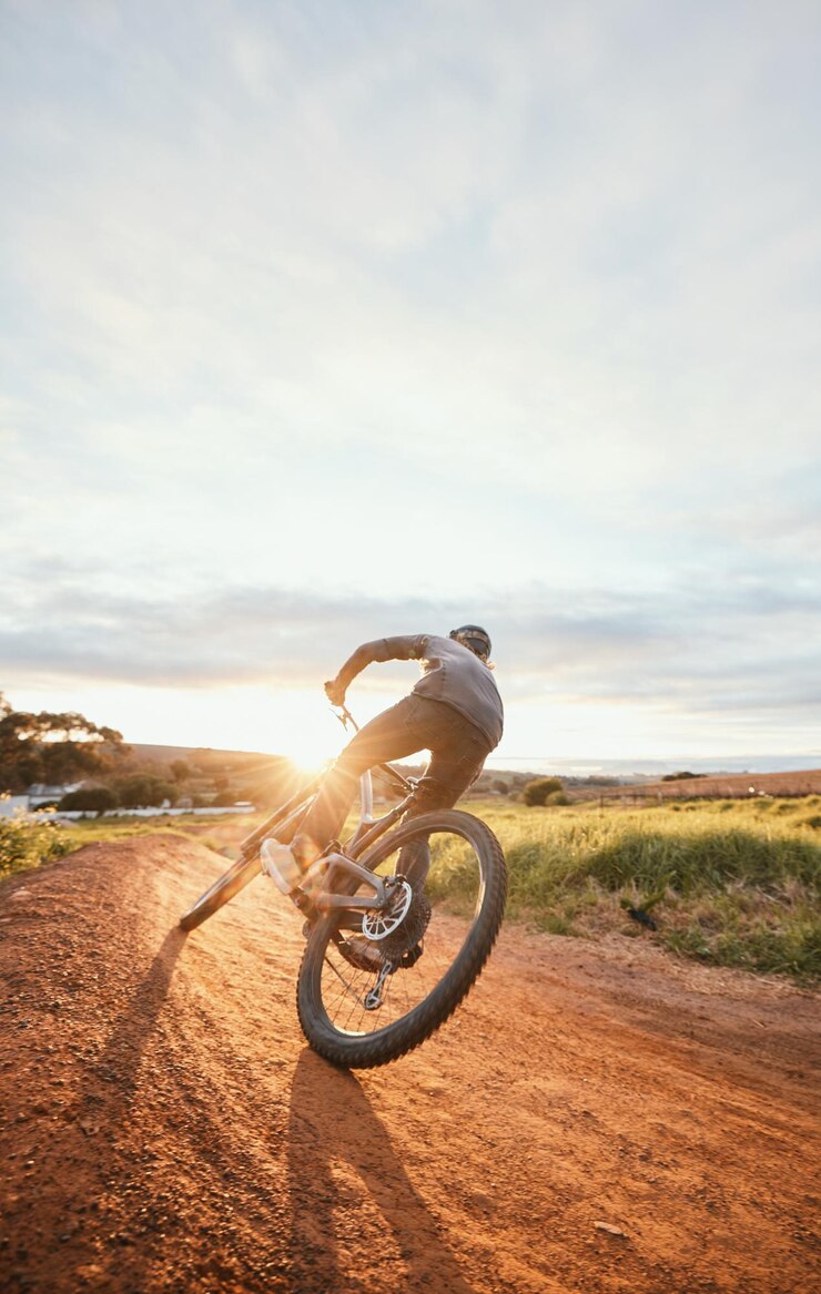 Foto sportlicher morgen und mann mit dem fahrrad in der natur zum training, training und training auf dem land. fitness-radfahren und männliche person mit mountainbike für abenteuerfreiheit und adrenalin auf unbefestigten straßen