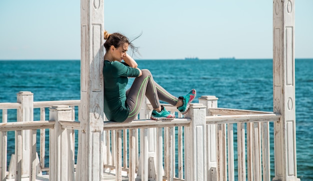 sportliches Mädchen auf dem Pier, das Übungen macht, um Fitness zu tun