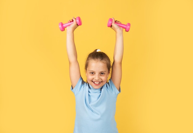 Sportliches mädchen mit hanteln fitness kinder gesundheit und energie gesunder kinderlebensstil kind trainiert mit...