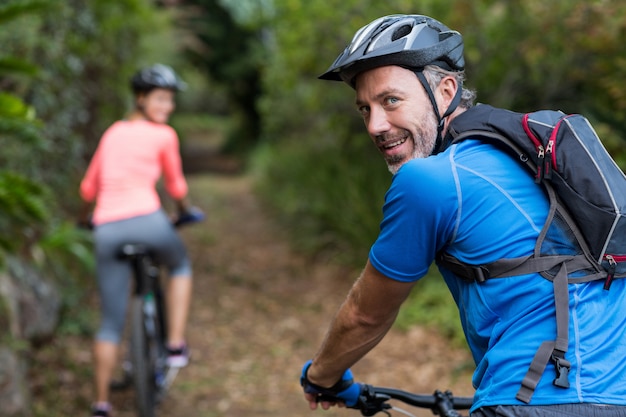 Sportliches Paar, das im Wald radelt