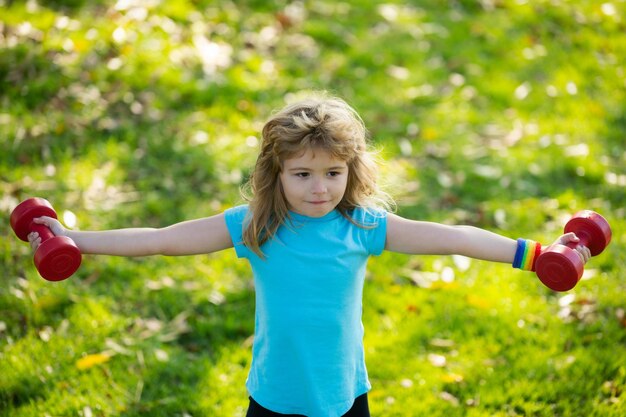 Sportliches Porträt Kinder Fitness-Kind mit Hanteln im Park Fitness-Studio Training Kind Sportler Kindheit Acti