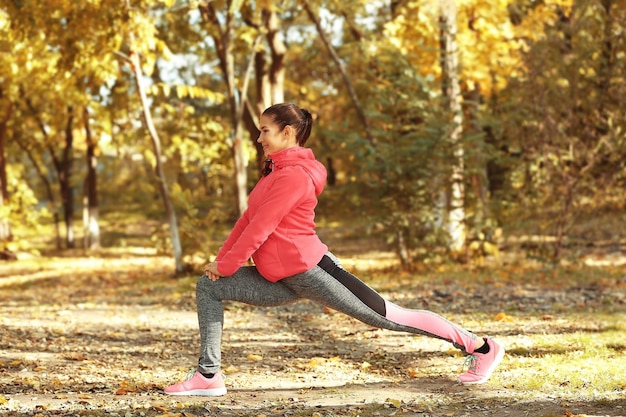 Sportliches Training der jungen Frau im Herbstpark