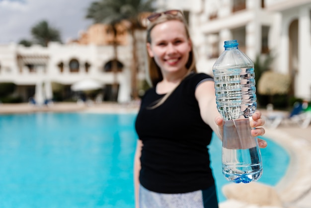 Sportmädchen von europäischem Aussehen hält eine Wasserflasche