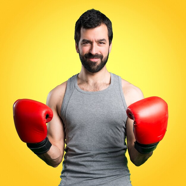 Sportman mit Boxhandschuhen auf buntem Hintergrund