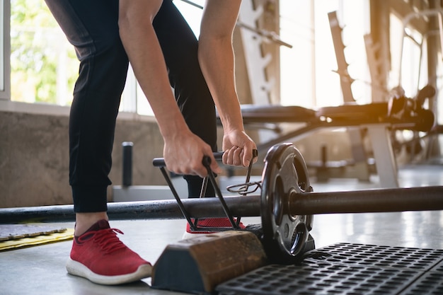 Sportmann-Übungstraining mit Hantel im Fitnessstudio