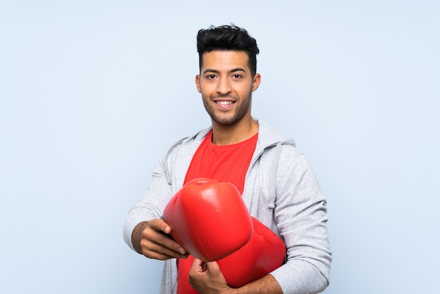 Sportmann mit Boxhandschuhen über lokalisierter blauer Wand