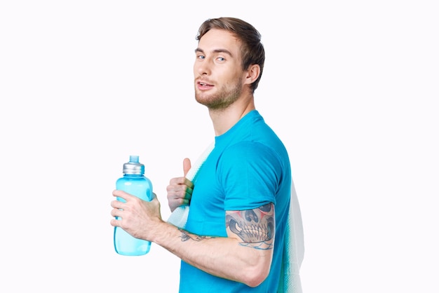 Sportmann mit Tätowierung auf seinem Arm Workout Wasserflasche beschnitten Ansicht Licht Hintergrund