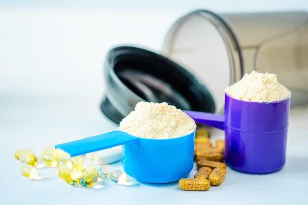 Sportpillen Vitamine und Proteinpulver mit brauner Flasche auf einem Tisch