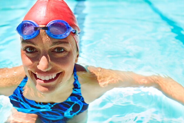 Foto sportporträt oder glückliche frau im schwimmbad für fitness-training cardio-workout oder energie lächeln übung und gesicht von weiblicher schwimmerin oder athletin mit schutzbrille für bewegung wellness oder aktivität