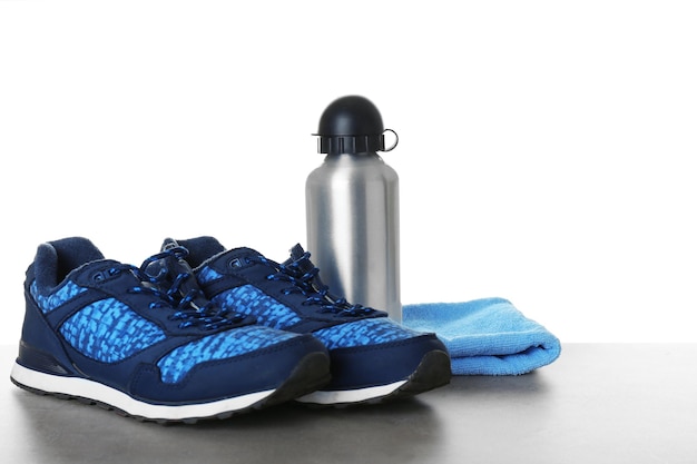 Sportschuhe Handtuch und Flasche auf dem Tisch