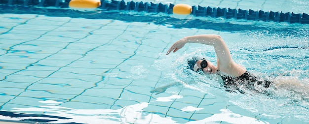 Sportschwimmen und Sportlerinnentraining für einen Wettkampf oder ein Turnier in einem Pool. Fitnesstraining und Schwimmerin, die eine Cardio-Wasserfertigkeit übt, um Geschwindigkeit oder Ausdauer zu trainieren