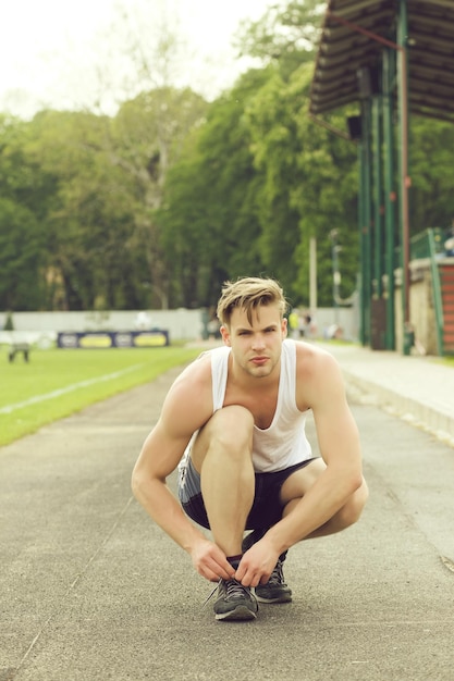 Sportsman ata a sus entrenadores sentados y preparándose para correr