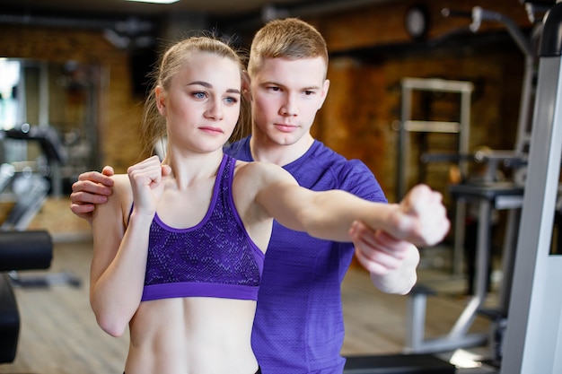Sportswoman treina boxe com o treinador no ginásio