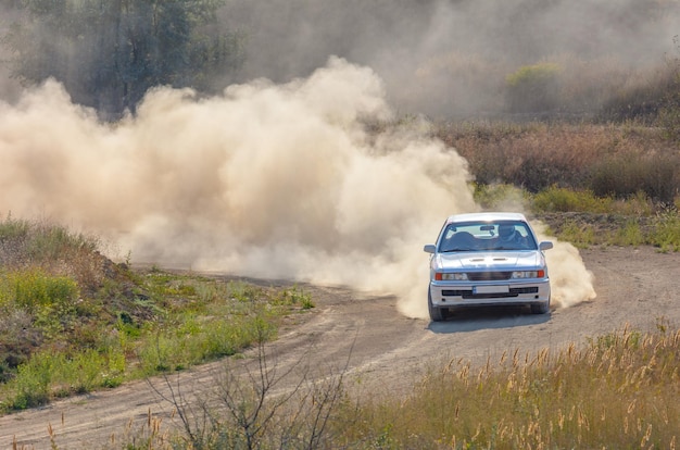 Sportwagen auf der Kurve der Rallyestrecke und viel Staub 10