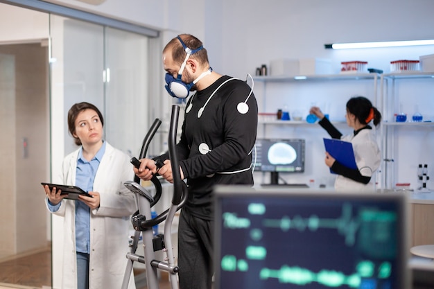 Sportwissenschaftler überwachen die Leistung des Cardio-, Herzfrequenz- und Cross-Training-Sportlers im Labor. Gesunder Körper ekg-Laborlauf.