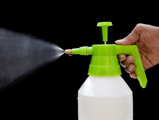 Foto spray de agua dulce de botella a mano aislado en negro