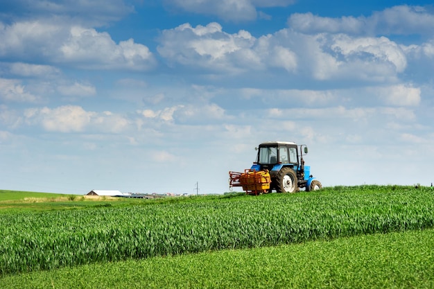 Sprayer in einem Weizenfeld im Frühjahr, die Hügel der landwirtschaftlichen Flächen