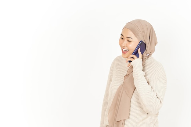 Sprechen am Telefon der schönen asiatischen Frau mit Hijab isoliert auf weißem Hintergrund