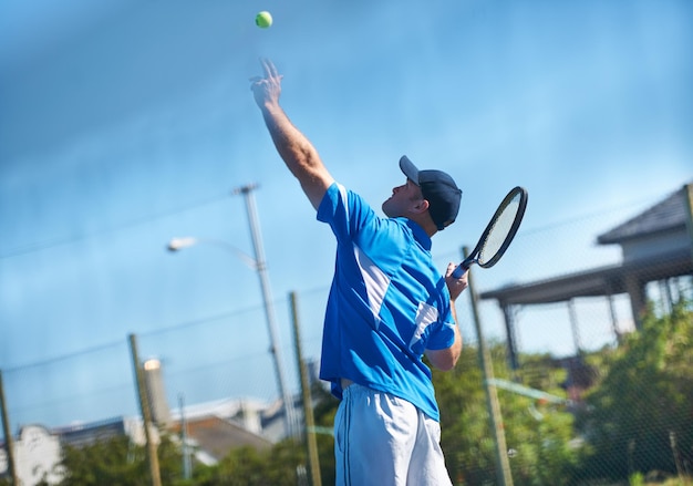 Sprengen eines Aufschlags Ein männlicher Tennisspieler, der den Ball für einen Aufschlag in die Luft wirft Tennis