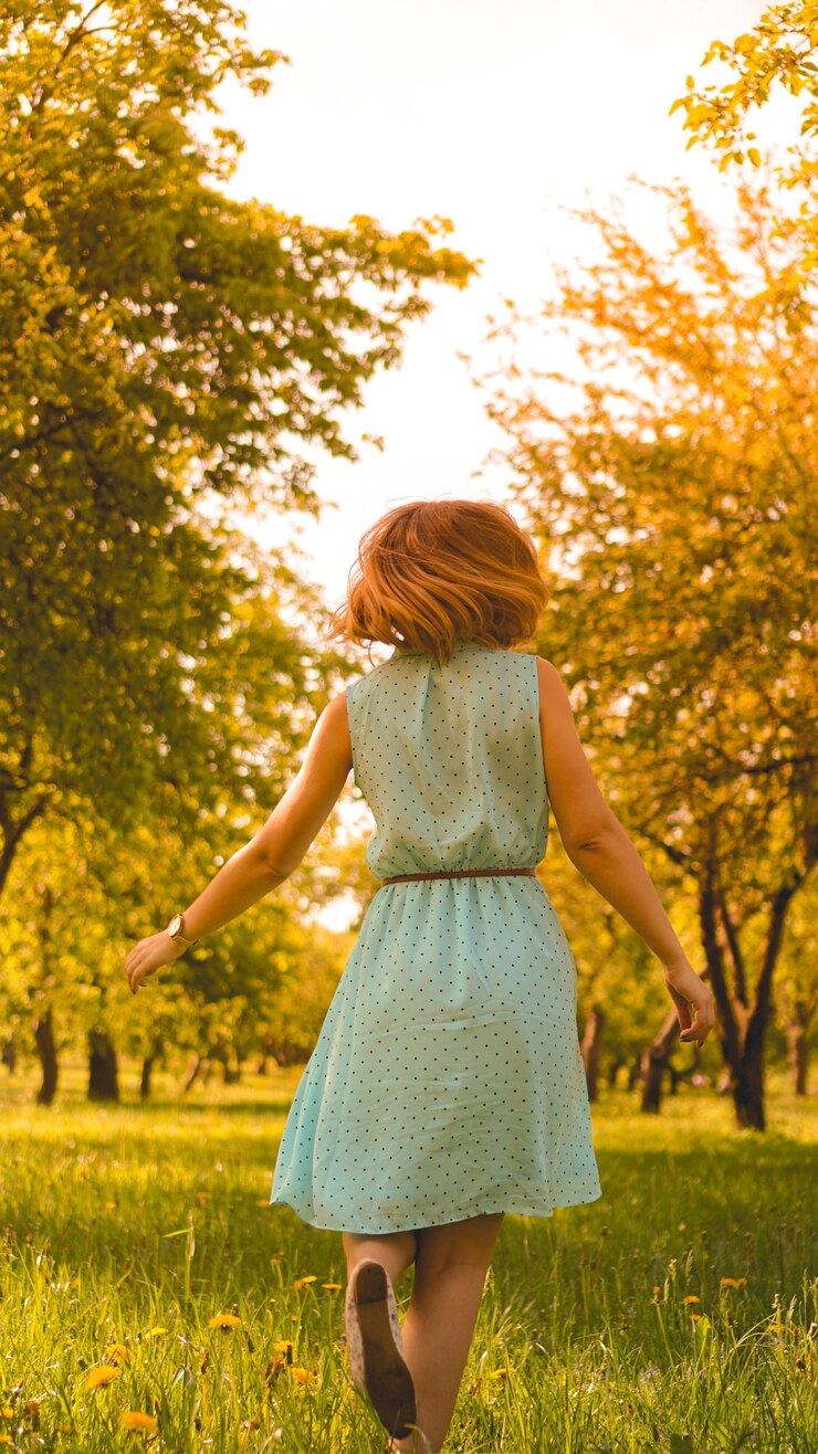 Spring Girl disfrutando de la naturaleza. Hermosa mujer joven al aire libre. Niña sana en el parque verde. Día soleado
