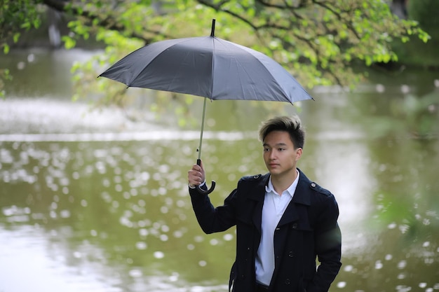 Spring Park bei Regenwetter und ein junger Mann mit Regenschirm