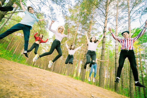 Foto springende teenager in spiellaune im sommerwald