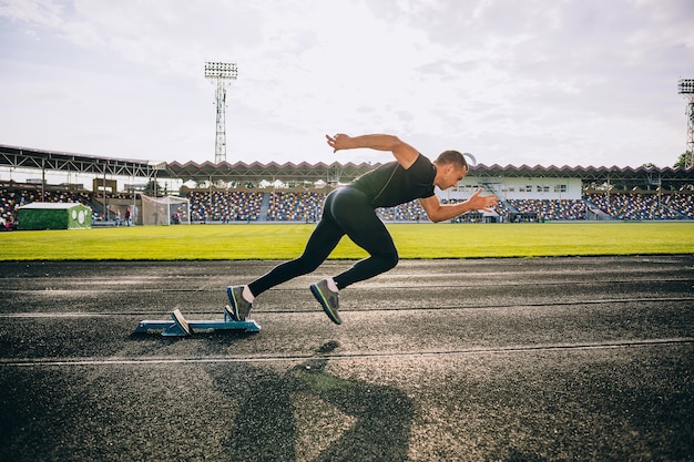 Sprinter dejando bloques de salida en la pista de atletismo