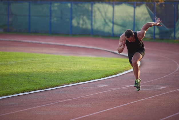 Sprinter dejando tacos de salida en la pista de atletismo. Comienzo explosivo.