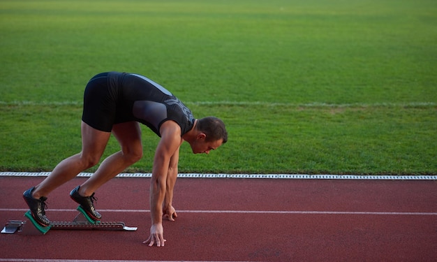 Sprinter dejando tacos de salida en la pista de atletismo. Comienzo explosivo.