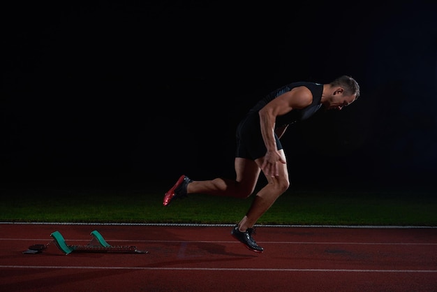 Sprinter dejando tacos de salida en la pista de atletismo. Comienzo explosivo.