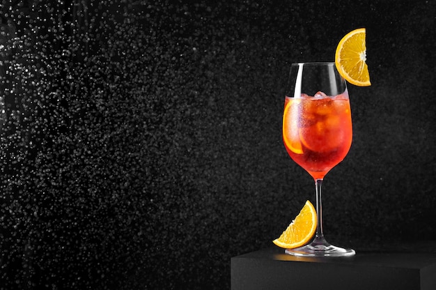 Spritz Cóctel en copa de vino con salpicaduras de agua sobre fondo oscuro