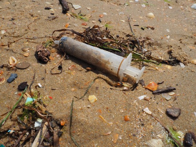 Spritze zur Injektion am Strand nasser Sand medizinischer Abfall als Umweltproblem intravenös dr