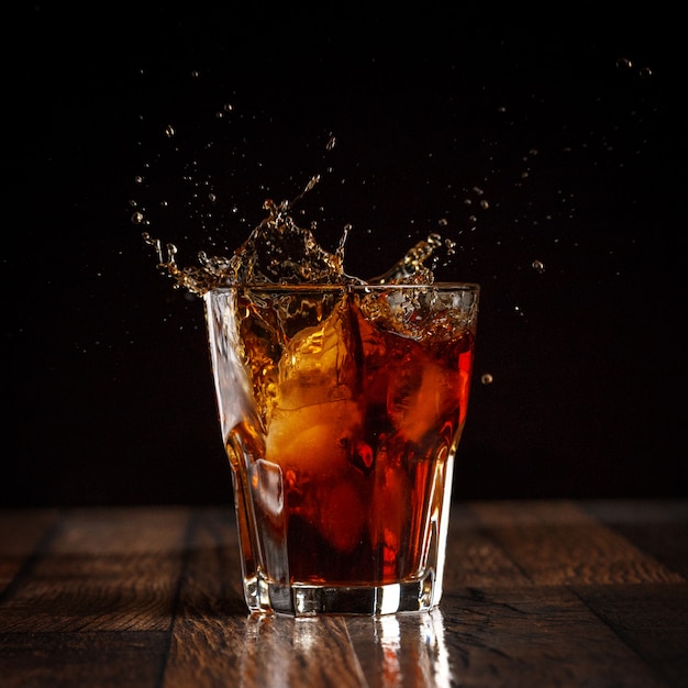 Foto spritzen sie im glas kolabaum mit eis auf grauem steigungshintergrund