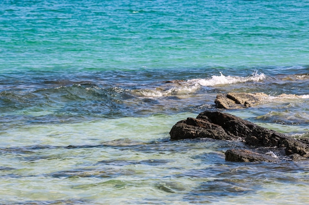 Spritzer Meerwasserwellen treffen den felsigen Strand