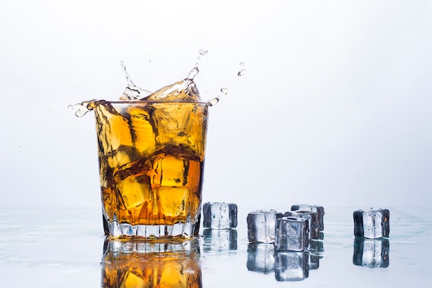 Spritzer Whisky aus Eiswürfeln. Konzept von alkoholischen Getränken mit Eis, Whisky oder Weinbrand, Apfelsaft und abkühlenden Getränken.