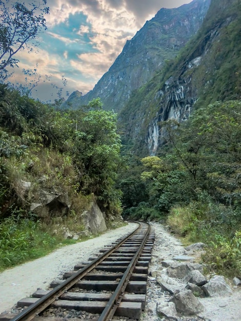 Spur eines Zuges um einen Dschungel in Cusco - Peru, im Hintergrund ein Wasserfall