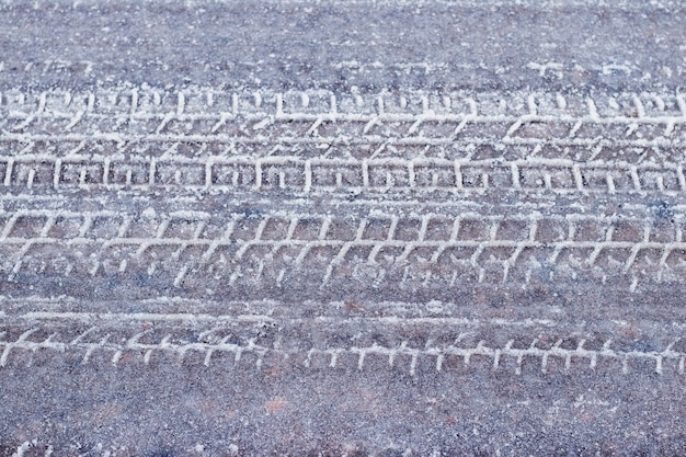 Spuren des Autos auf einer verschneiten Straße im Winter