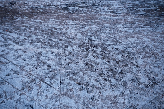 Spuren von Asphaltschnee, Eis, Personenspuren von Schuhen auf Schnee, Schneeräumungswetter