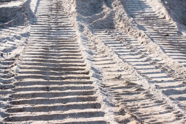 Spuren von Reifen auf der Oberfläche einer Sandgrube das Konzept eines Steinbruchs