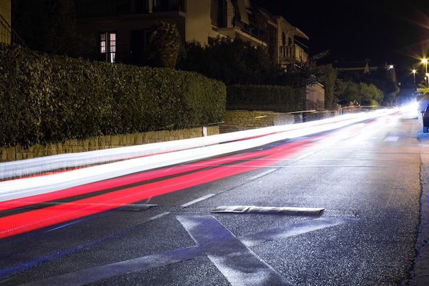 Spuren von vorbeifahrenden Autos. Nachtstraße mit Geistern von Autolichtern Lange Exposition. Hintergrund.