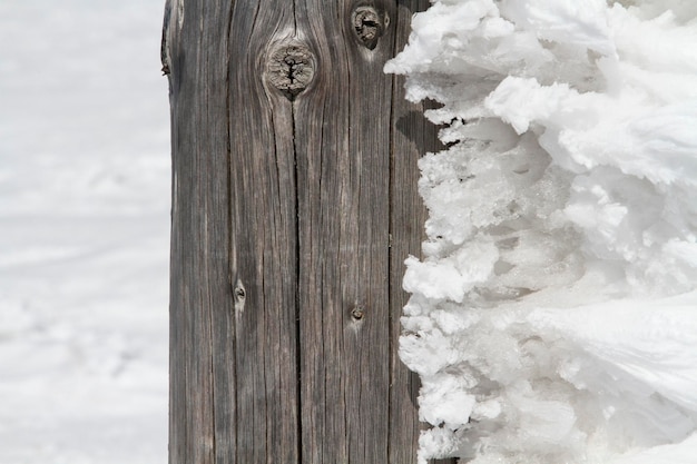 Spuren von Windaktivität Gefrorener Schnee auf dem Holzzaun