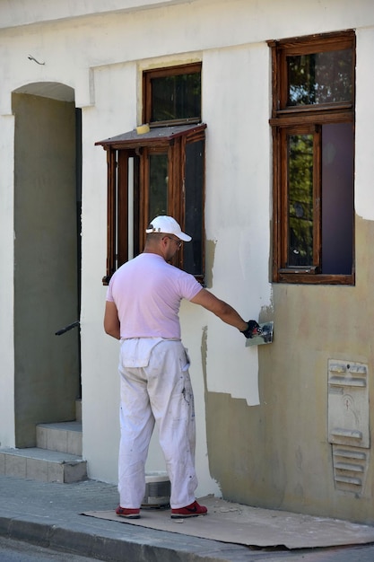 Sremski Karlovci Serbia 21 de abril de 2018 Trabajador alisando la textura de la pared exterior de la casa