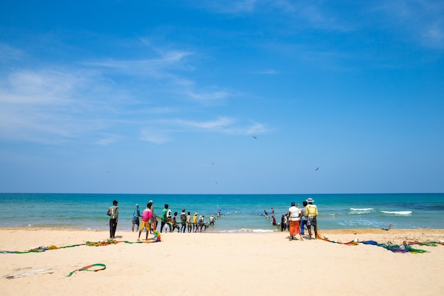 SRI LANKA - Mach 23: Pescadores locais puxam uma rede de pesca do Oceano Índico em Mach 23, 2017 em Kosgoda, Sri Lanka. A pesca no Sri Lanka é a forma como eles ganham a vida.