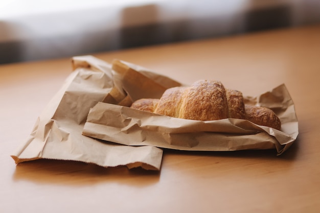 Sroissant auf Holztisch. Morgen zu Hause.