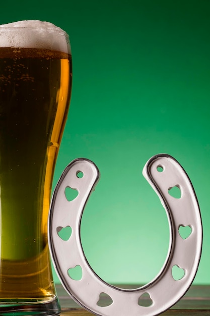St. Patrick's Day Bier und glückliches Hufeisen vor grünem Hintergrund