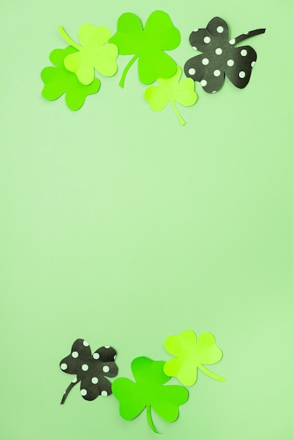 St. Patrick's Day minimalistisches Konzept Papierkleeblätter auf farbigem Hintergrund mit Kopierraum