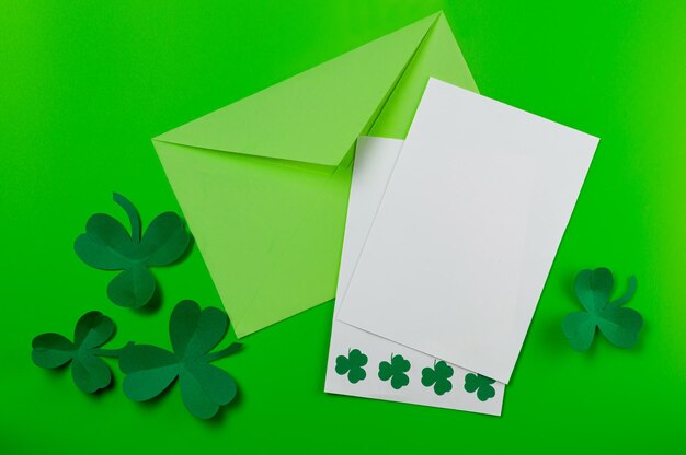 Foto st patricks maquete de cartão em branco envelope trevo de papel trevos em fundo verde