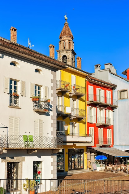 St. Peter und Paul Kirchturm und Fassaden von Gebäuden im luxuriösen Resort in Ascona am Lago Maggiore im Kanton Tessin in der Schweiz. Menschen im Hintergrund