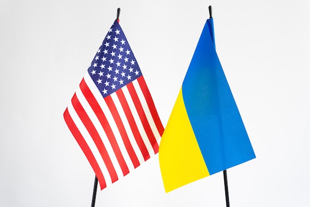 Staatsflagge der Ukraine und der USA auf weißem Hintergrund Freundschaftshilfesymbol für die Zusammenarbeit zwischen Amerika und der Ukraine