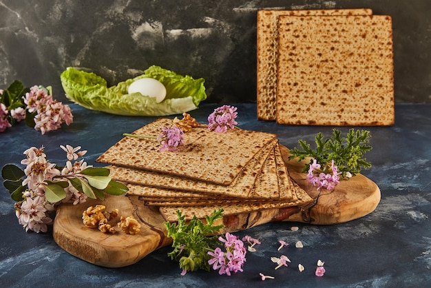 Stack de matzo en tablero de madera con flores nueces para el diseño floral